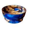 A small decorative bowl made from swirling blue resin and natural wood, shown on a plain white background.
